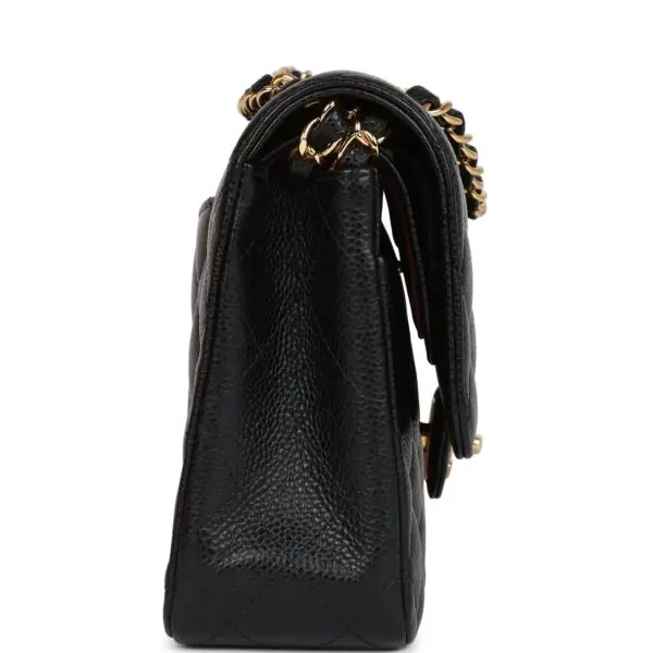 The Chanel Medium Classic Double Flap Bag Black Caviar Gold Hardware has a gold chain attached to it.