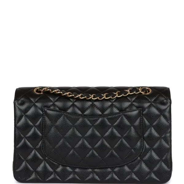 The Chanel Medium Classic Double Flap Bag Black Caviar Gold Hardware in black.