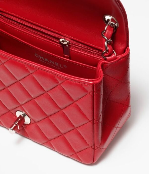 Chanel's red Mini Flap Bag in white background.