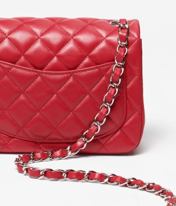 Chanel's red Mini Flap Bag in white background.