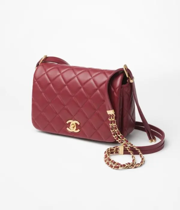 Chanel red small flap bag in white background.