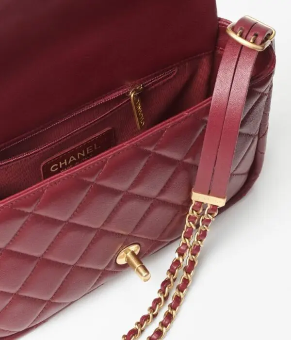 Chanel red small flap bag in white background.