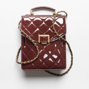 A burgundy quilted SMALL FLAP BAG with a gold chain.