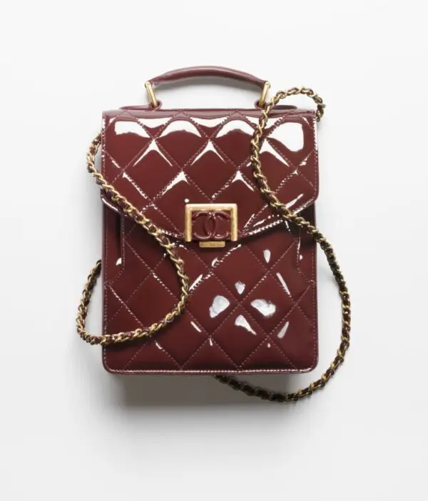 A burgundy quilted SMALL FLAP BAG with a gold chain.