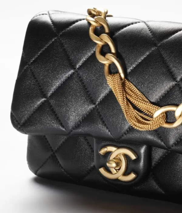 Chanel small black flap bag with gold chain.